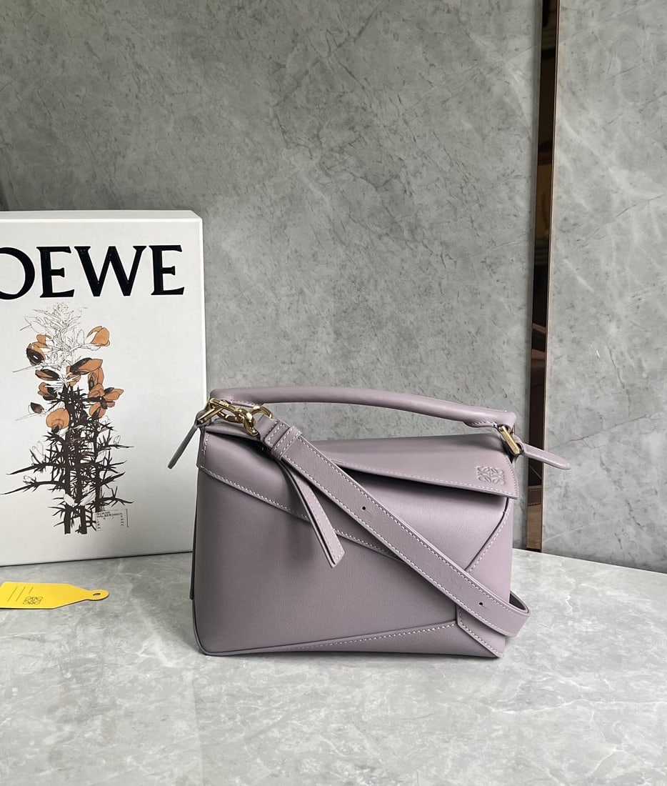 LOEWE: LOEWE Premium Taro Purple Puzzle Bag is made of calfskin, with a sand colored patchwork design throughout. It's lightweight yet has a surprisingly large capacity, making it practical, versatile, and