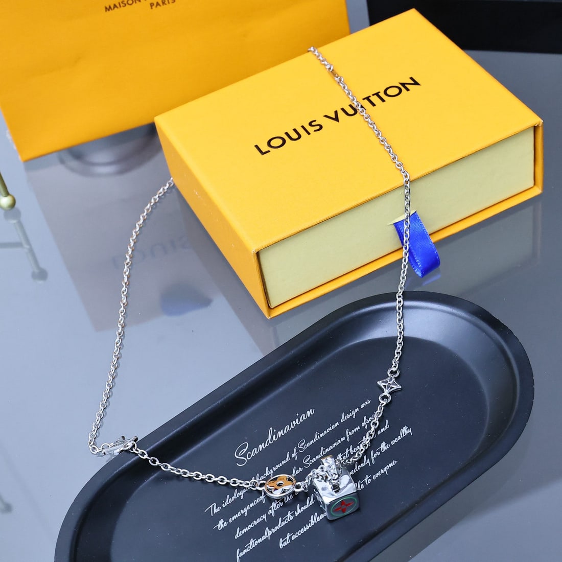 LV DICE pendant: The LV DICE pendant, designed by Pharrell Williams, features multiple surfaces adorned with patterns of varying shapes and colors, subtly paying homage to classic elements. It can be worn alone or lay