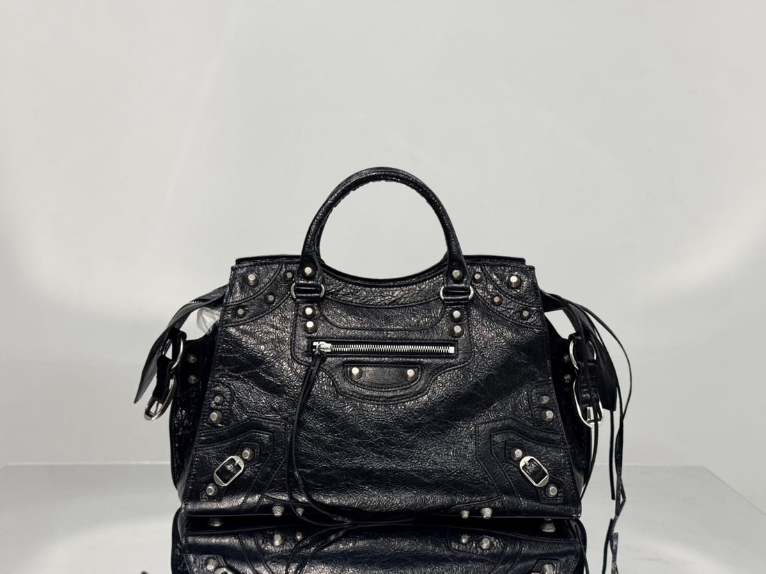 Balenciaga motorcycle bag: The Balenciaga Neo Cagole motorcycle bag combines the classic Neo Classic Le Cagole design with Italian crackled lambskin. It retains the iconic motorcycle bag elements such as rivets and tassels, whi