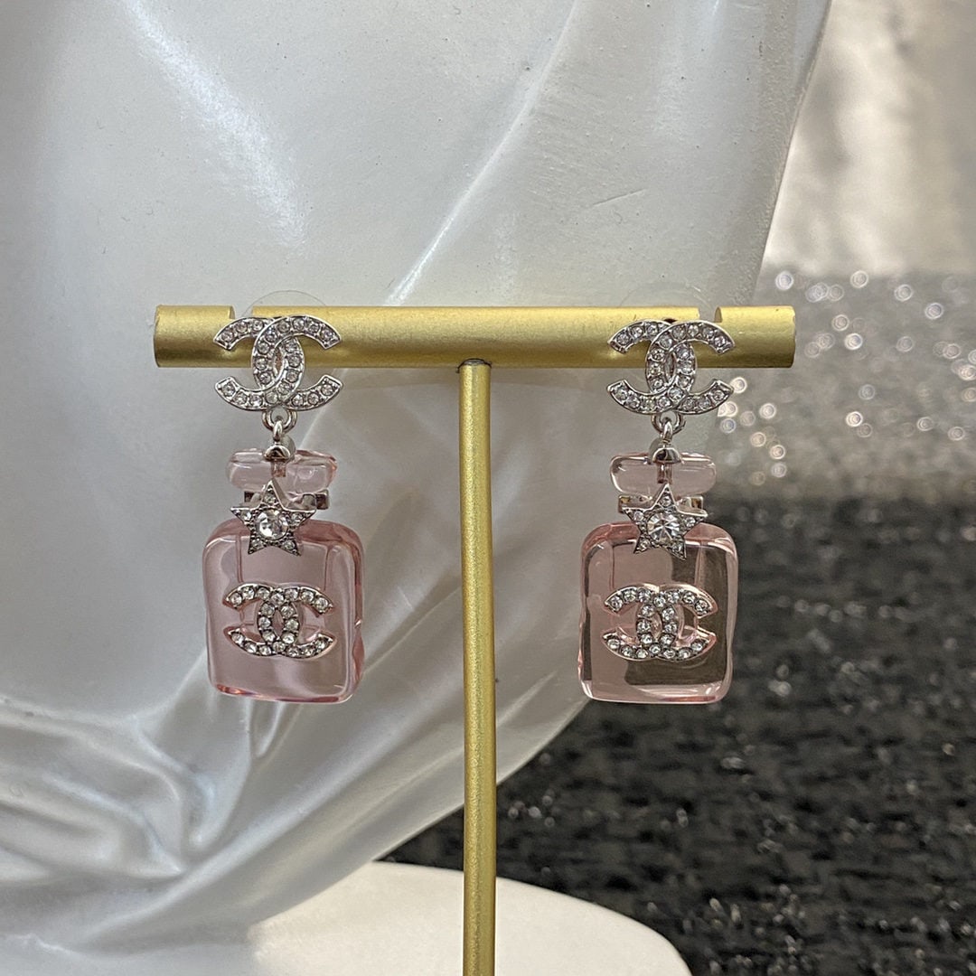 Chanel earrings in a jelly pink perfume bottle design, double C earrings.: Chanel jelly pink perfume bottle double C earrings are delicate, clear, and perfect for summer. The translucent look, paired with rhinestones, is absolutely gorgeous. We offer FREE SHIPPING for both d