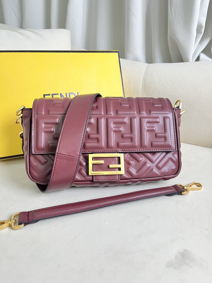Fendi Baguette: This wine red Baguette leather handbag, Iconic Baguette medium size, is crafted from soft Nappa leather and adorned with a three dimensional textured FF pattern. It features an FF clasp, a front flap,