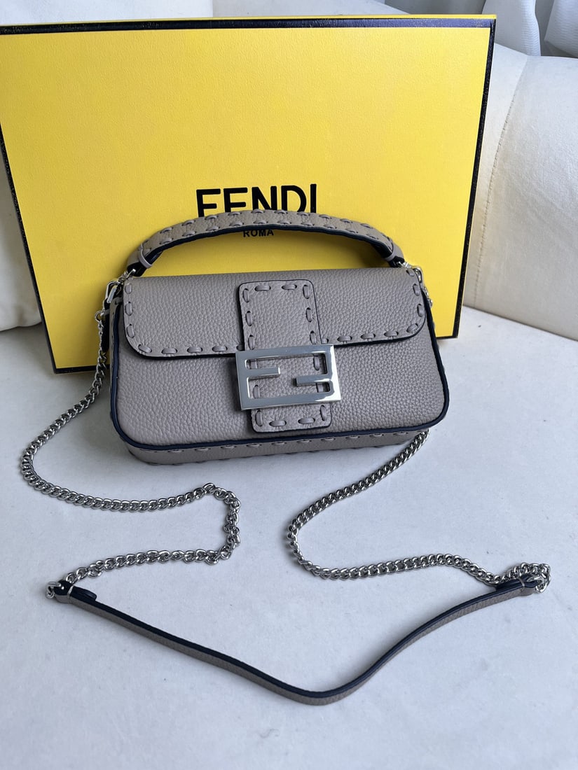 Fendi hand stitched baguette family members: This dove grey hand stitched baguette, a member of the family, features hand stitched cowhide leather, top grade all steel vintage hardware, and exclusive craftsmanship, resulting in a wonderfully sof