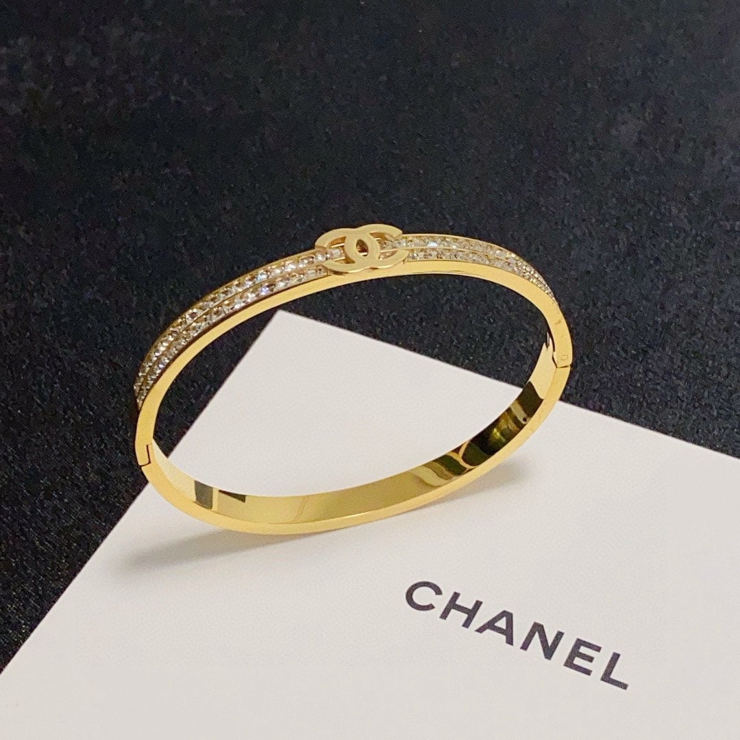 CHANEL C shaped bracelet with double rows of diamond encrusted C logo.: CHANEL double row diamond encrusted C shaped bangle. A high quality Chanel bangle with a beautifully matched color scheme, exuding a sophisticated and goddess like aura. A truly captivating and classi