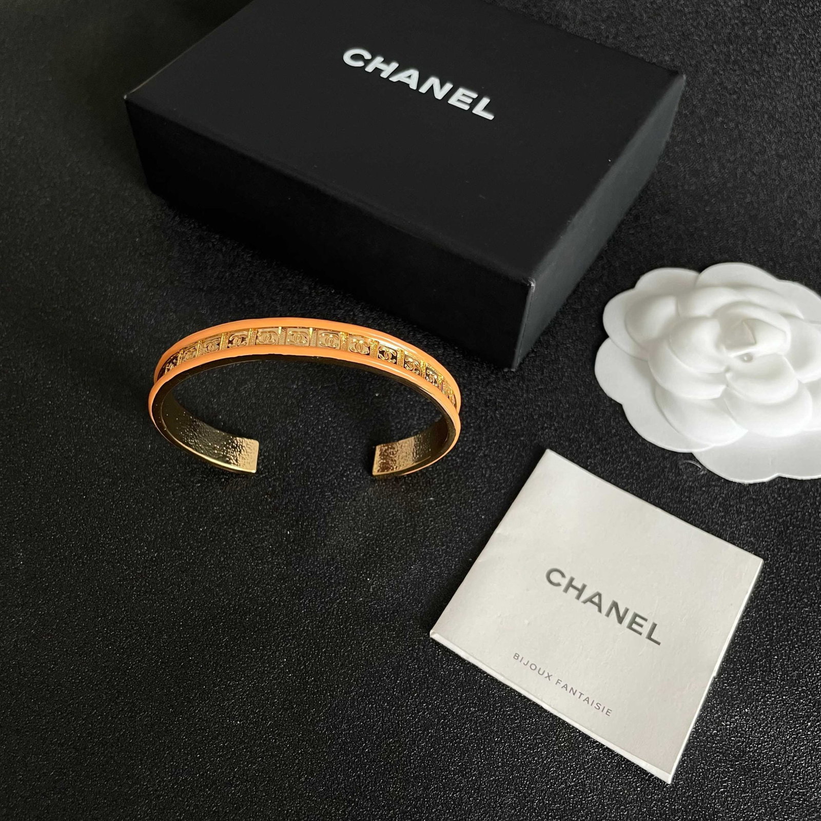 CHANEL double C logo engraved orange bracelet: A Chanel orange bracelet with the double C logo engraved on it. A high quality Chanel colored bracelet with a beautifully matched color scheme. It exudes a sophisticated, goddess like aura, a classic 