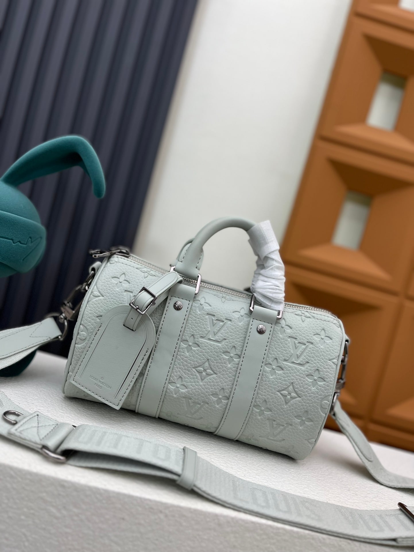 Keepall Bandouliere 25 handbag: The Keepall Bandouliere 25 handbag is crafted from Monogram embossed Taurillon leather. Leather side straps and a leather top handle highlight the signature elements of the Keepall collection, while a