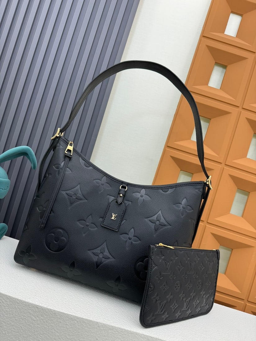 CarryAll Medium Handbag: This CarryAll medium sized handbag is crafted from Monogram Empreinte embossed leather, its soft texture conforming to the body. It features a detachable zip pocket that can accommodate a laptop, meet