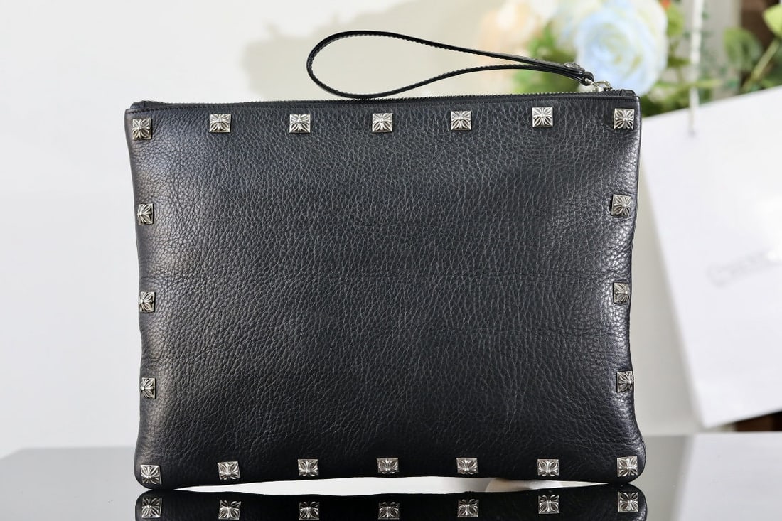 Chrome Hearts Chrome Hearts Square Nail Handbag: Chrome Hearts clutch with silver accents; 40 square studs in total (front and back); 1 horseshoe zipper pull; 1 sword shaped zipper tag; leather; dimensions: 31 x 24.5 cm. We offer FREE SHIPPING for b