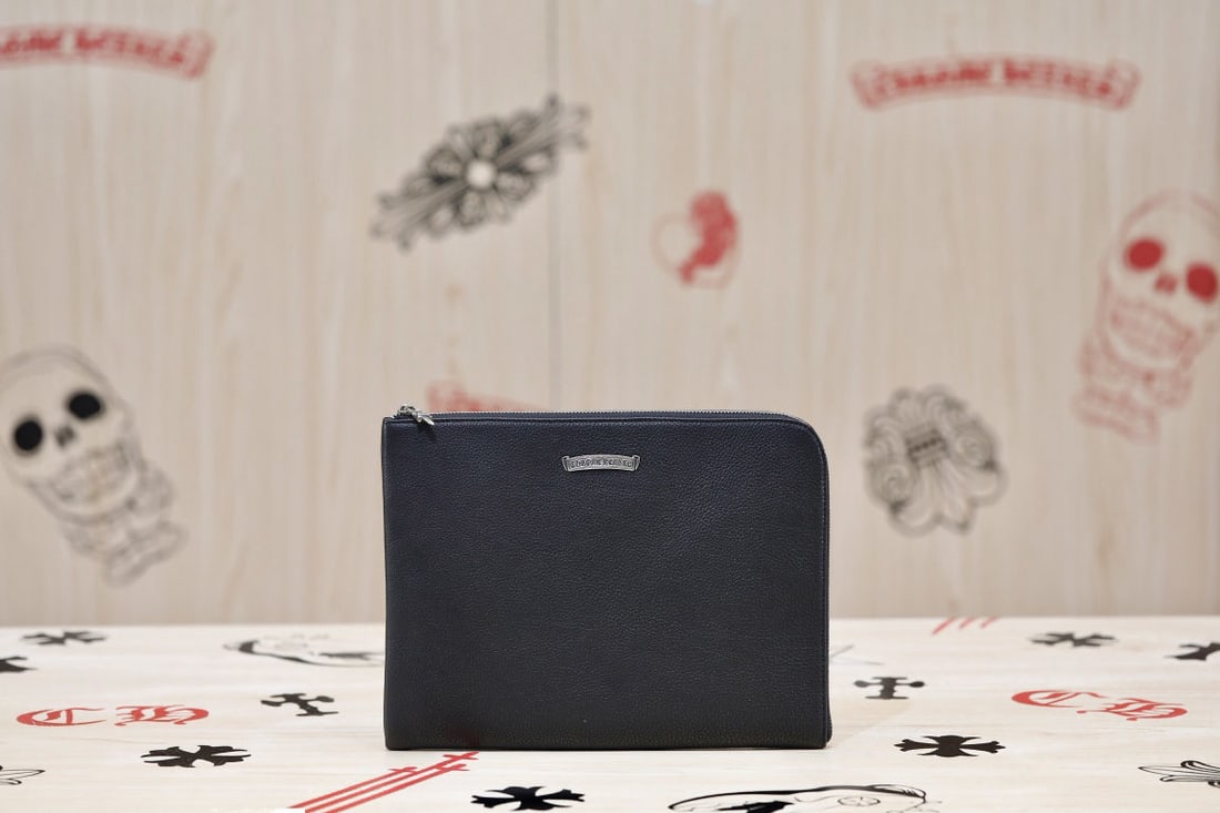 Chrome Hearts Tablet Handbag: The Chrome Hearts tablet clutch is crafted from durable, tumbled cowhide leather, and features 925 sterling silver hardware throughout. Its dark design blends rock, gothic, and punk influences, yet ex