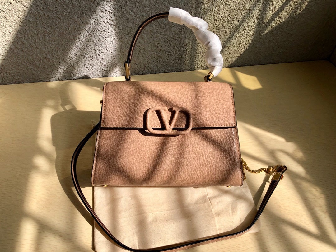 Valentino Garavani VSLING: Apricot Valentino Garavani VSLING briefcase with a palm print design. Features an extendable two tone shoulder strap and handles for easy switching between shoulder, crossbody, and hand carry. Vintage