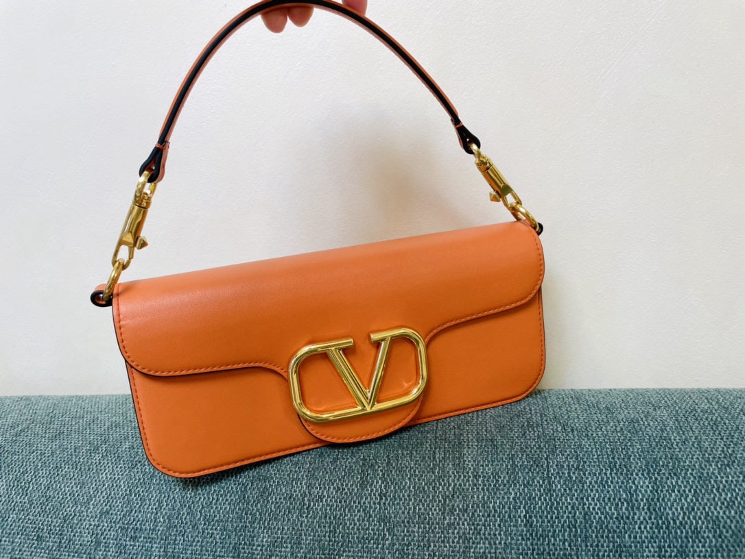 Valentino VLogoSignacar: Valentino calfskin handbag with metal V logo Signacar trim features detachable handles and a detachable sliding chain for shoulder, crossbody, or hand carrying. Vintage brass distressed finish hardwar