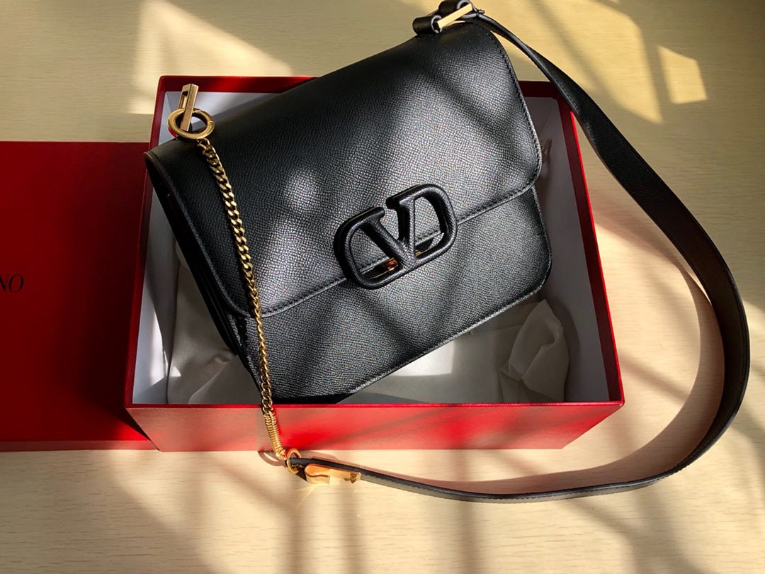 Valentino: This Valentino 19 vintage shoulder bag features a palm print design and a large V shaped buckle. Made from imported cowhide, it boasts a distinctive large logo buckle for easy opening and closing. The