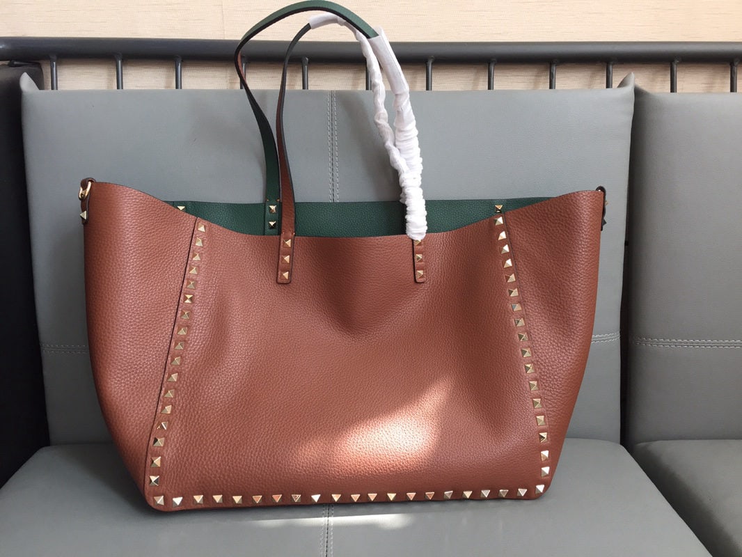 Valentino: Brown and green Valentino reversible shopping bag, made of double sided studded tumbled leather. One bag is equivalent to two bags ?C a winter essential with extra large capacity. Dimensions: 33 x 26 