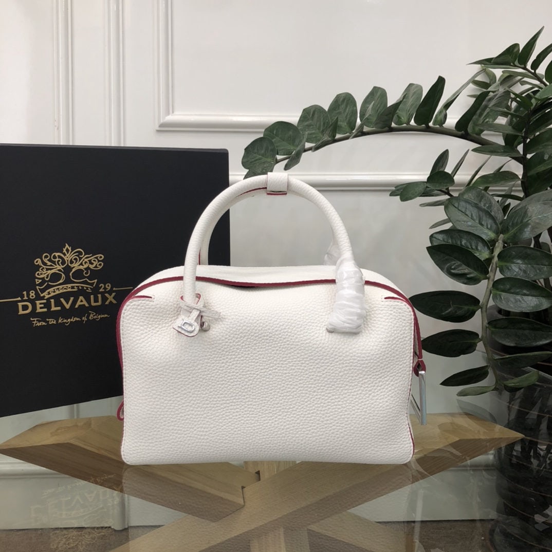 Delvaux: The most striking feature of the Delvau semi handcrafted Cool Box is its unique D shaped pull tab and cubic structure. Unlined, the Cool Box offers ample interior space, is lightweight, and highly fun