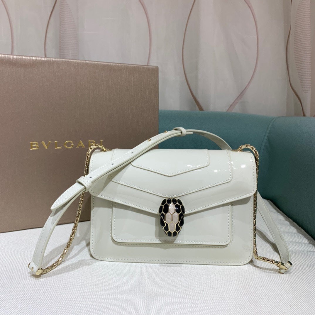 Bvlgari Serpenti Forever: The Serpenti Forever crossbody bag is stylish and versatile. This bag is crafted from white agate colored calfskin with a pearlescent lacquer finish, adorned with black and red enamel accents and blac