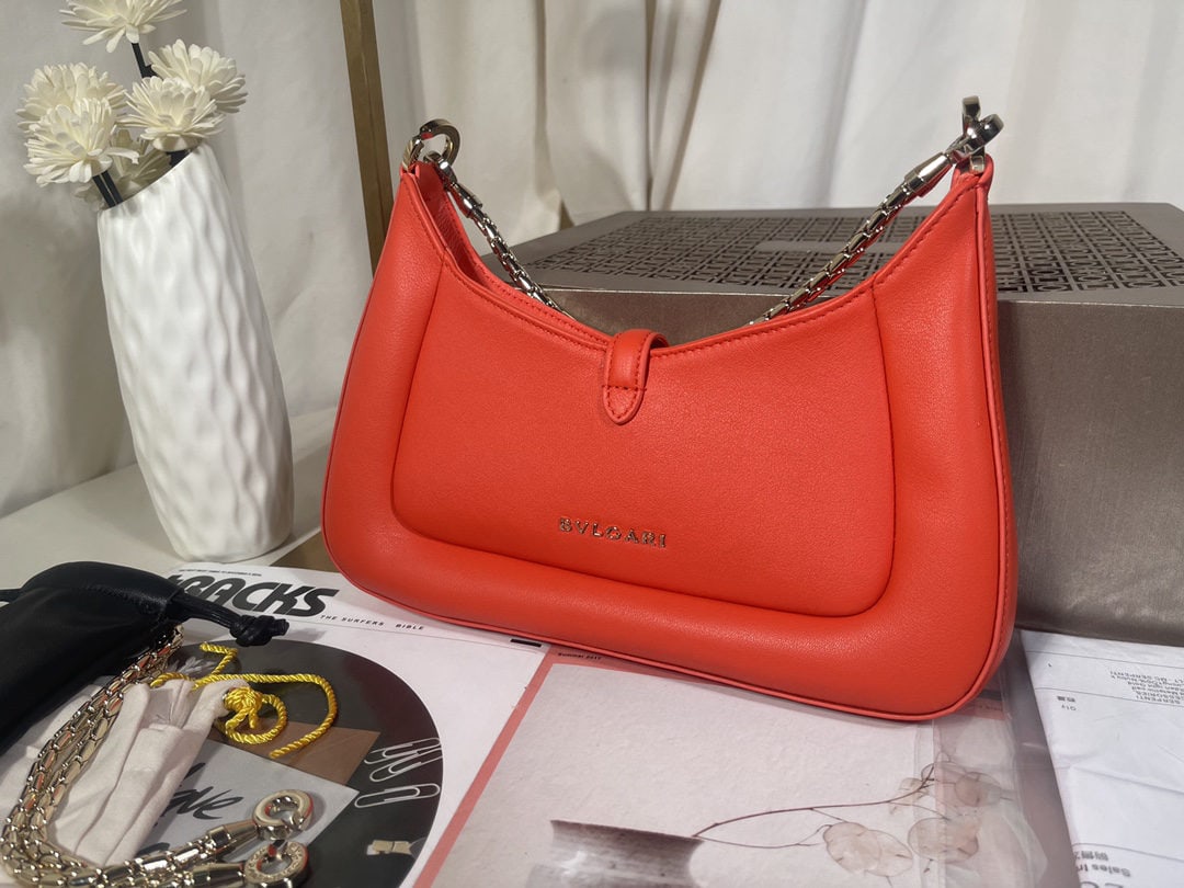 Bvlgari SERPENTI BAIA: The Bvlgari SERPENTI BAIA small shoulder bag is crafted from supple and durable orange red calfskin. The extendable shoulder strap is adorned with the iconic snakehead magnetic clasp and alluring scal