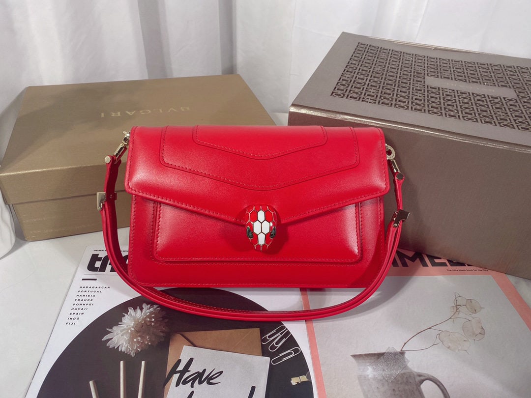 Bvlgari SERPENTI FOREVER EAST WEST: SERPENTI FOREVER EAST WEST series small shoulder bag, crafted from garnet red calfskin, features a practical leather shoulder strap adorned with a classic snakesnake head magnetic closure. Versatile a
