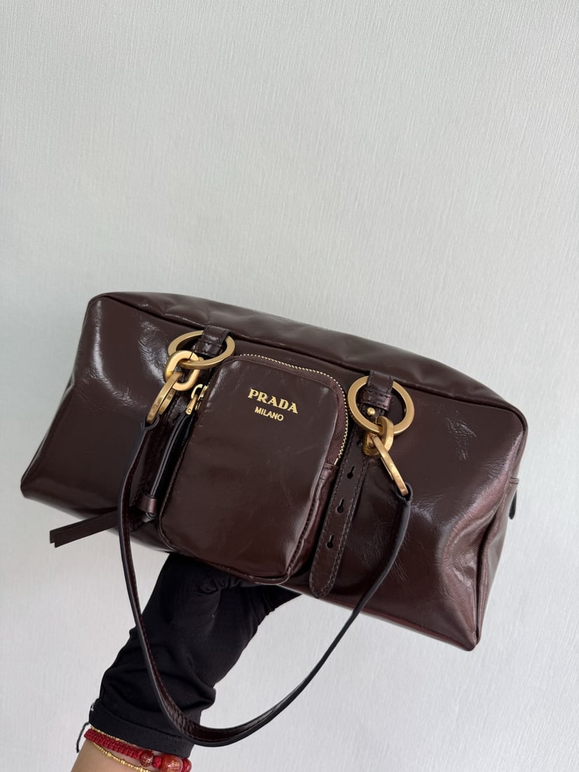 PRADA shoulder bag: This oil waxed leather shoulder bag features a fresh interpretation of design with soft, oil waxed leather. Vintage metal hardware and a classic zippered pocket add to its retro charm. It can be