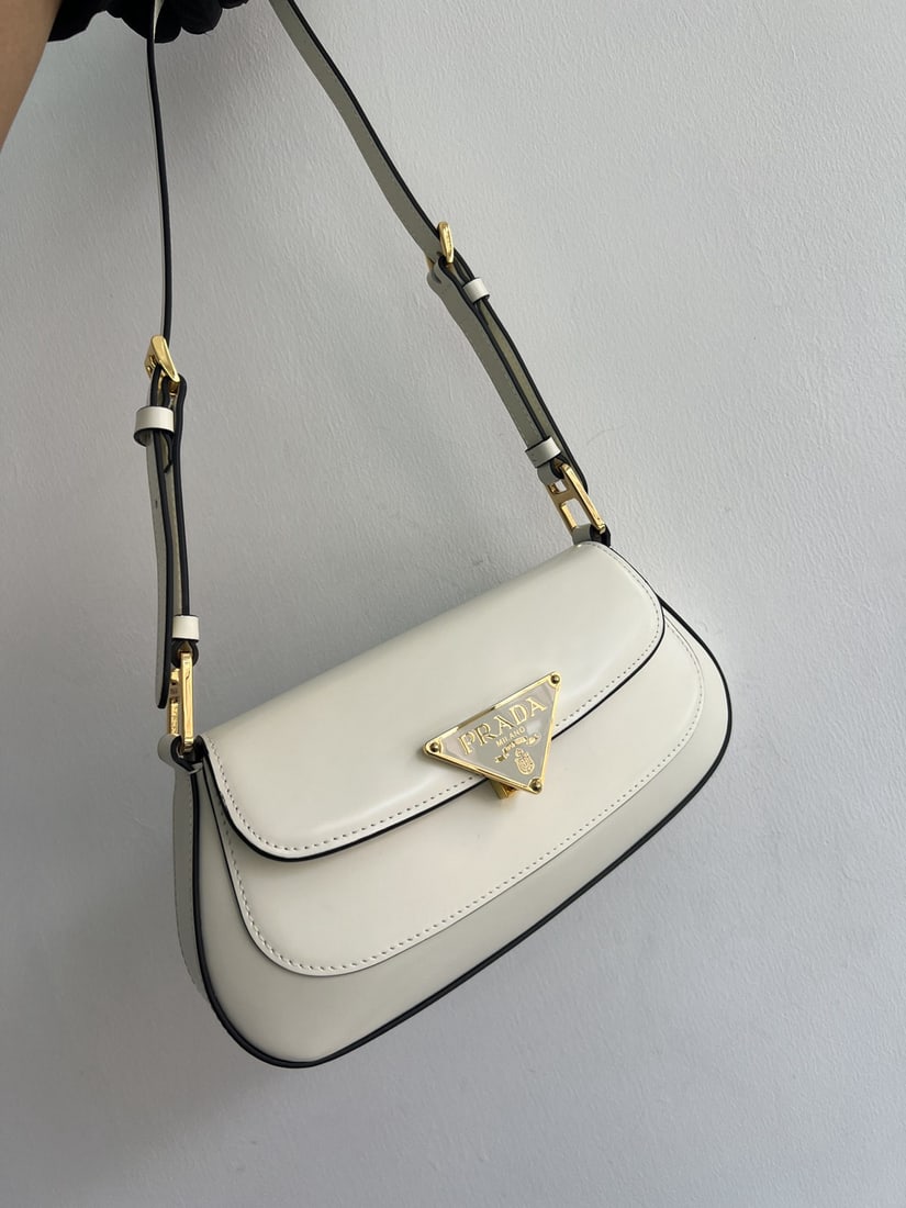 PRADA underarm bag: The underarm bag's sleek, curved design lends it a sophisticated and modern charm. Versatile in style, it features two adjustable shoulder straps of varying lengths, suitable for use as a handbag or c
