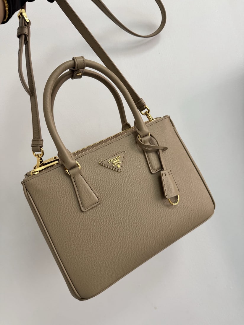 PRADA: Made with imported cross grain cowhide and top quality brushed hardware, the Galleria handbag features a classic and timeless design, the iconic "killer bag," a style that will never go out of fashion