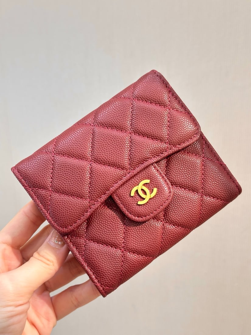 CHANEL Coin Purse: This burgundy one can function as both a coin purse and a card holder. It's a classic design with a double C metal logo on the front, a flip top snap closure, and enough capacity to meet your everyday