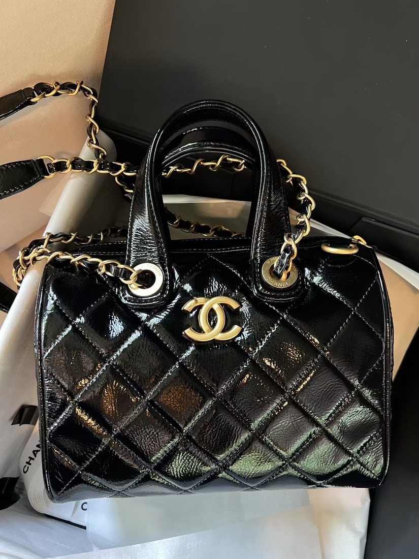 CHANEL Bowling: This bowling style bag is made of high quality waxed cowhide, giving it a stylish and sophisticated look. It features a circular clasp for attaching accessories and can be carried by hand, crossbody, 