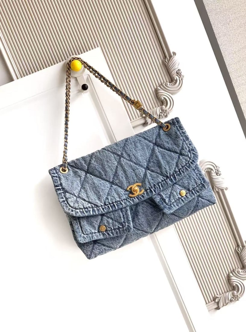 CHANEL Fall/Winter Limited Edition Shopping Bag: This limited edition CHANEL Fall/Winter shopping bag features a denim design with gold tone metal double pockets and a vintage chain pendant, instantly elevating the classic quilted look. The gold dou