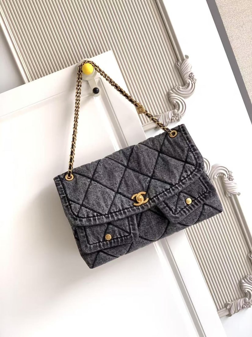 CHANEL Fall/Winter Limited Edition Shopping Bag: This limited edition CHANEL Fall/Winter shopping bag features a denim design with gold tone metal double pockets and a vintage chain pendant, instantly elevating the classic quilted look. The gold dou