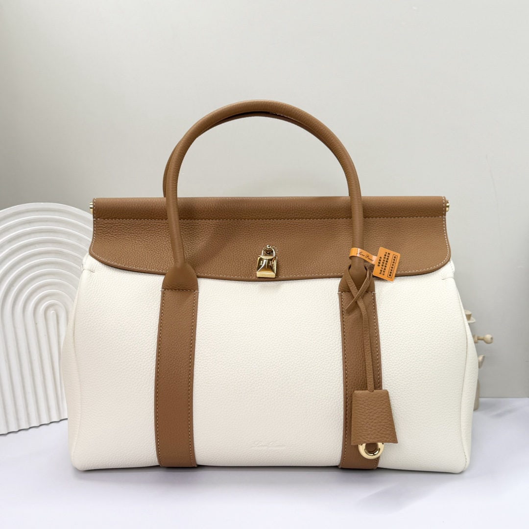 Loro piana Loro piana Loom L32 Handbag: The Loro Piana Loom L32 tote bag is crafted from premium calfskin leather with a suede lining, offering a unique and lightweight feel. It features a delicate padlock that can be opened, exuding a casu