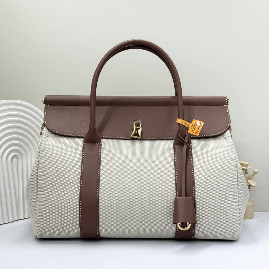 Loro piana Loro piana Loom L32 Handbag: The Loro Piana Loom L32 canvas caramel handbag is crafted from premium calfskin with a suede lining, offering a unique and lightweight feel. It features a delicate padlock that can be opened, exuding 