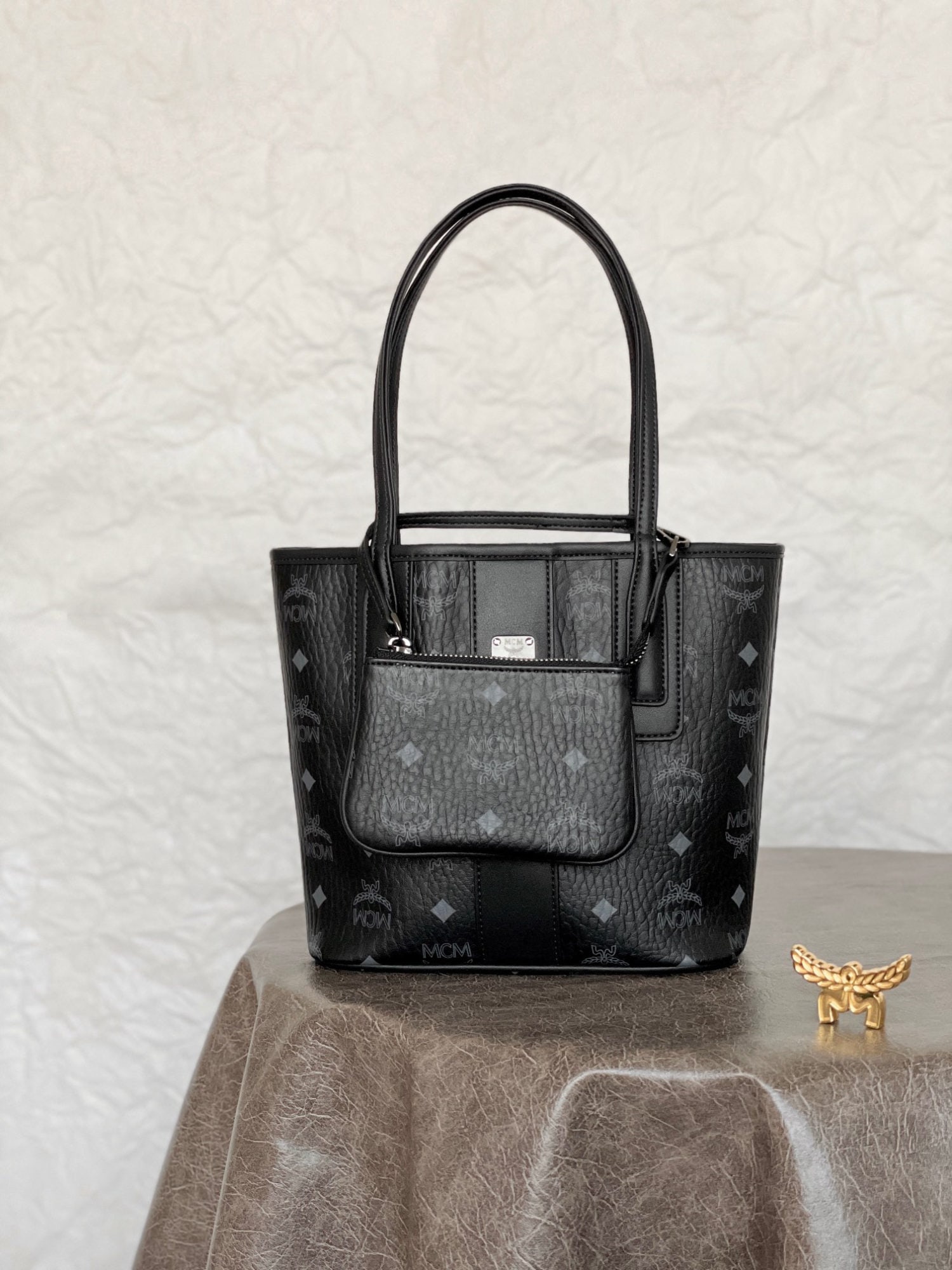 MCM Liz Visetos Mini Reversible Shopping Tote Bag: MCM Liz Visetos Mini Reversible Tote Bag in Classic Black. Classic MCM minimalism is presented through a modern, minimalist design. This mini tote bag is a scaled-down version of the iconic Liz tote b