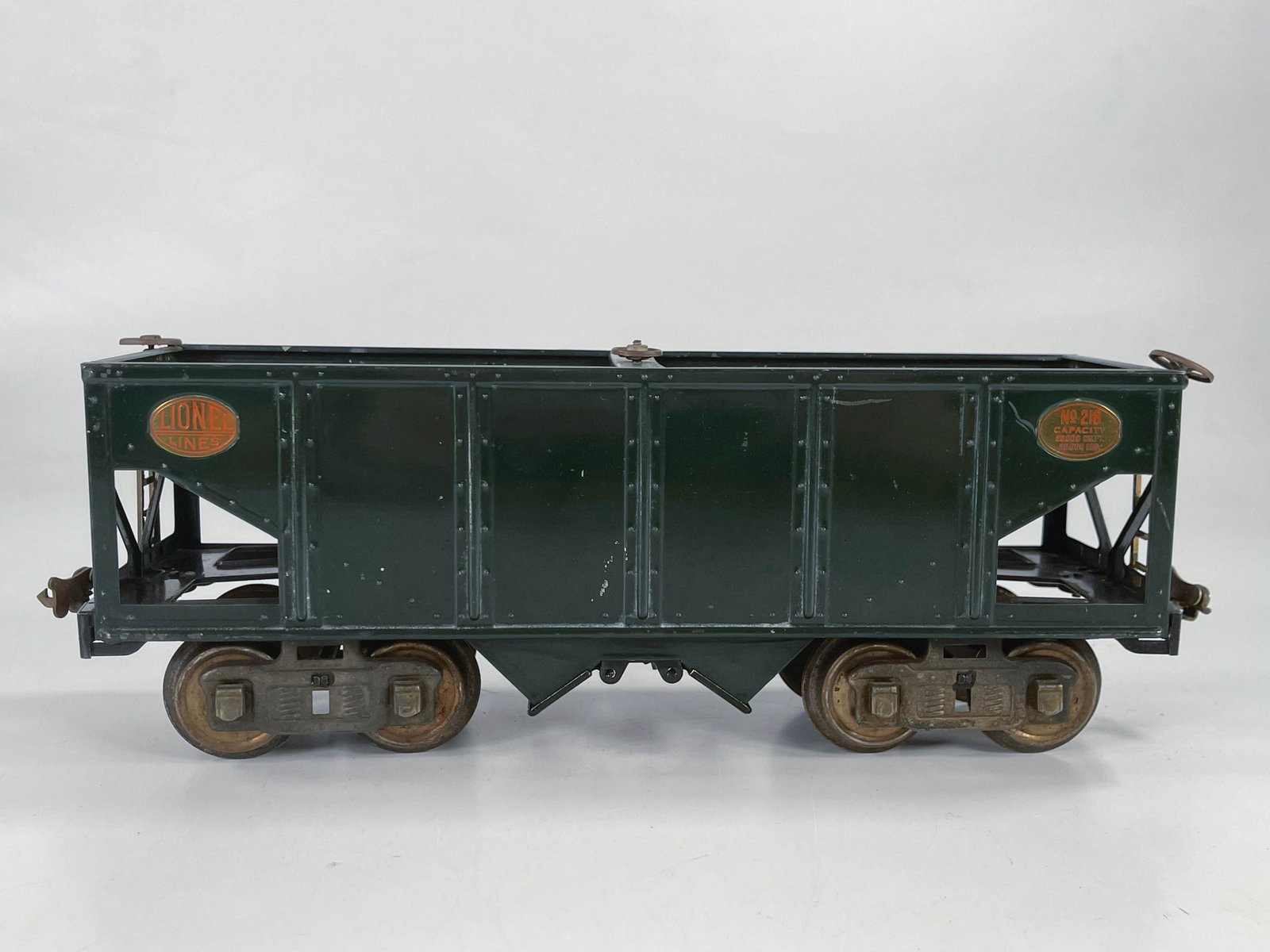 Lionel Prewar #216 green hopper with brass plates: Lionel Prewar #216 green hopper with brass plates, in C7 minus although the trucks and some of the brass hardware are rusting.