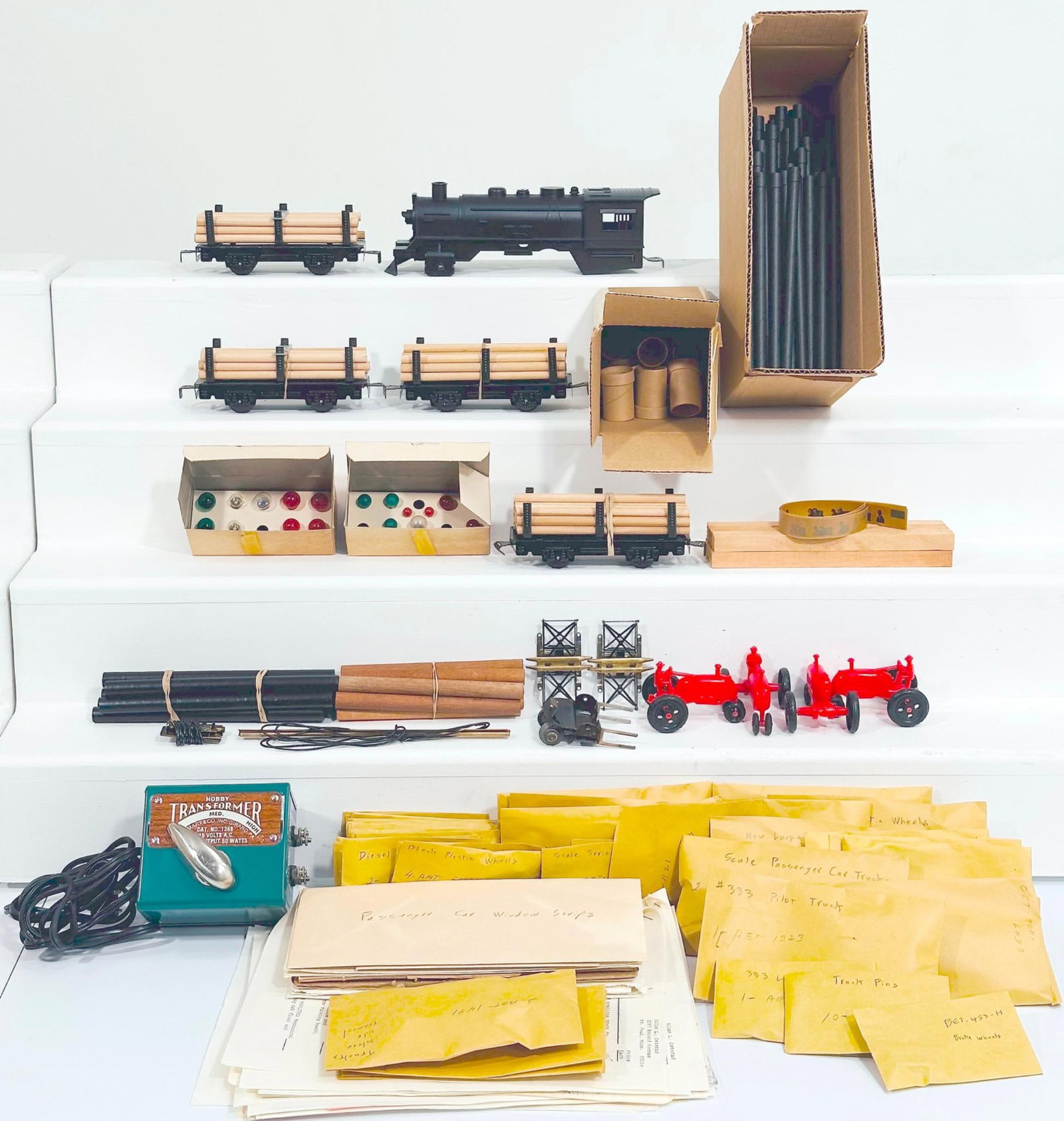 Marx Postwar O Gauge Plastic Locomotive shell only and Three (3) Assorted Flat Cars with loads: Marx Postwar O Gauge Plastic Locomotive shell only and Three (3) Assorted Flat Cars with loads/miscellaneous parts envelope, each in C7 or better.