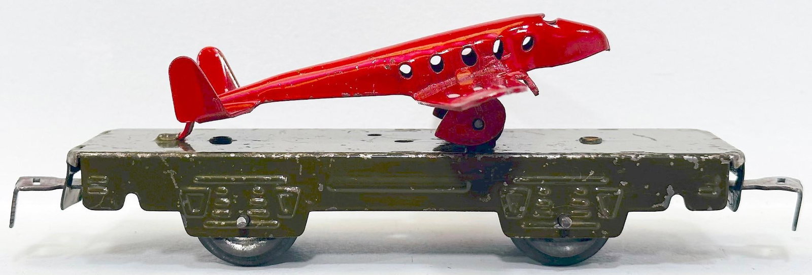Marx Postwar O Gauge 572A 4 Wheel Olive Flat Car with a red Aircraft Mounted: Marx Postwar O Gauge 572A 4 Wheel Olive Flat Car with a red Aircraft Mounted, in C6 plus. Longest item in this Lot is 7 inches.