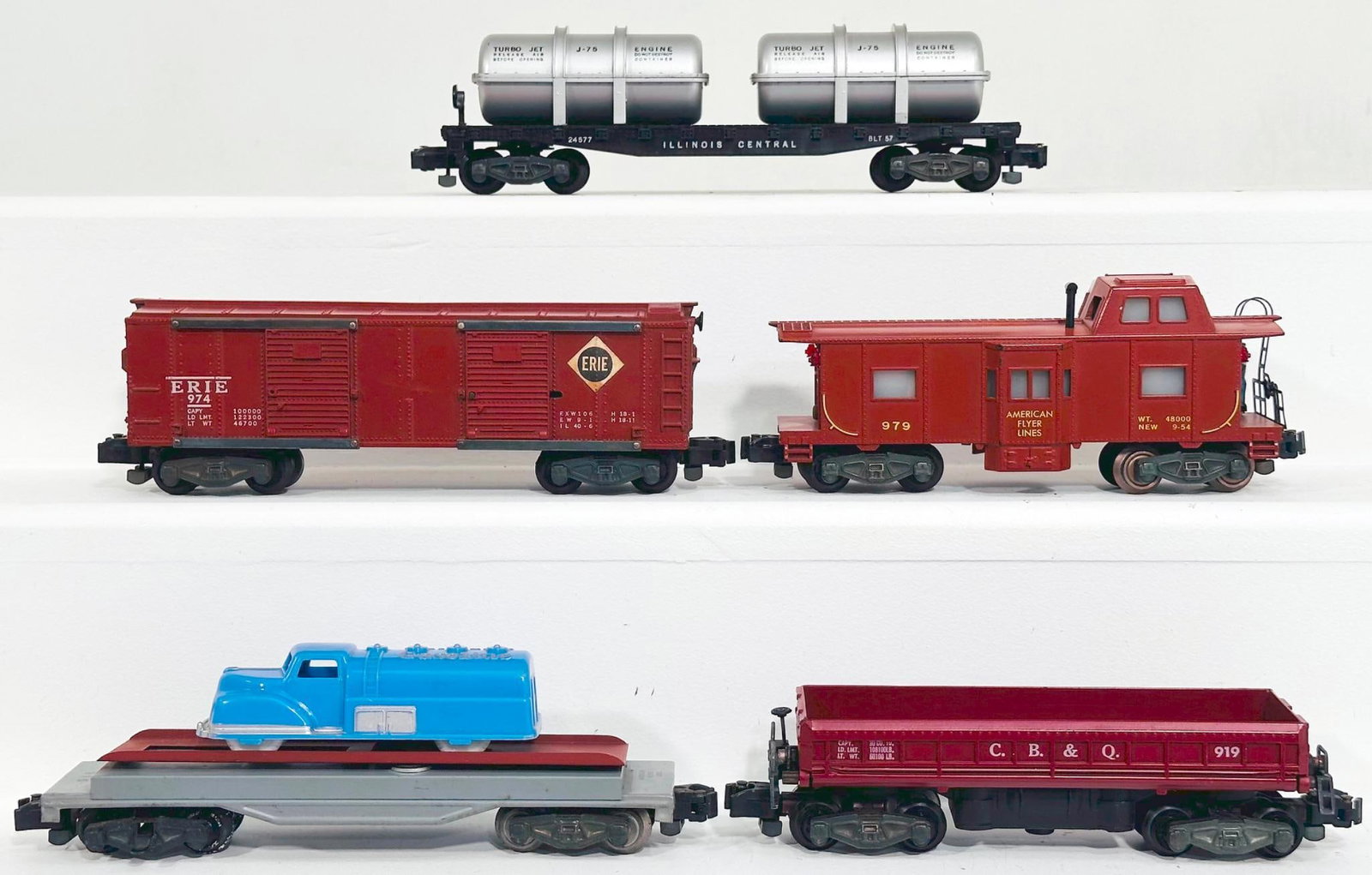 American Flyer Postwar S Gauge Five (5) Assorted Freight Cars: American Flyer Postwar S Gauge Five (5) Assorted Freight Cars, including 24577 Illinois Central Flat Car with wood load, 974 Erie Lackawanna, 915 Vehicle Unloading Car with load, 919 CB & Q Dump C