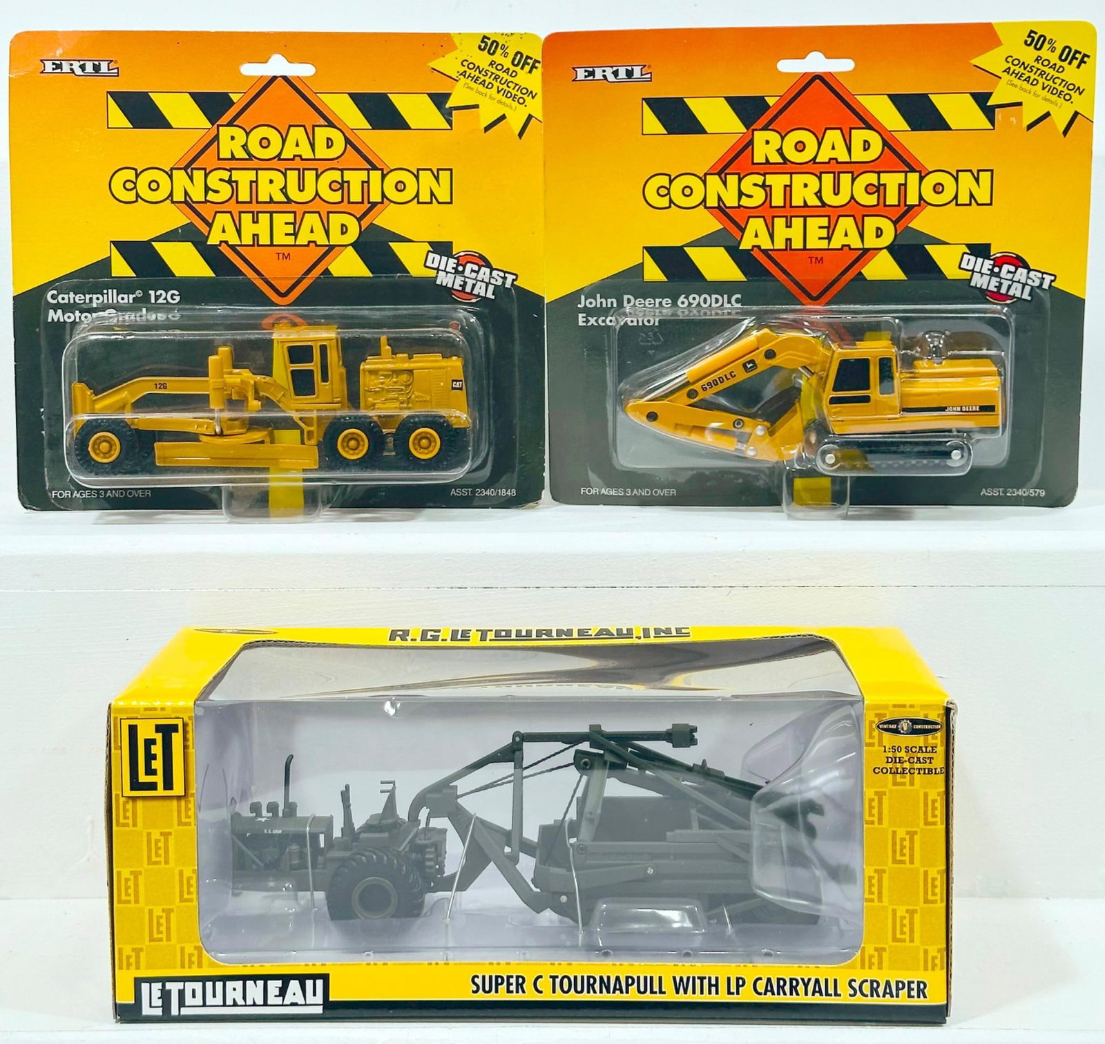 LeTourneau Modern 1:50 Scale Super C Tournapull and Ertl Modern Die-Cast CAT 12 G Motor Grader and: LeTourneau Modern 1:50 Scale Super C Tournapull and Ertl Modern Die-Cast CAT 12 G Motor Grader and John Deere 690DLC Excavator Boxed, each in C9 and each with its original box.