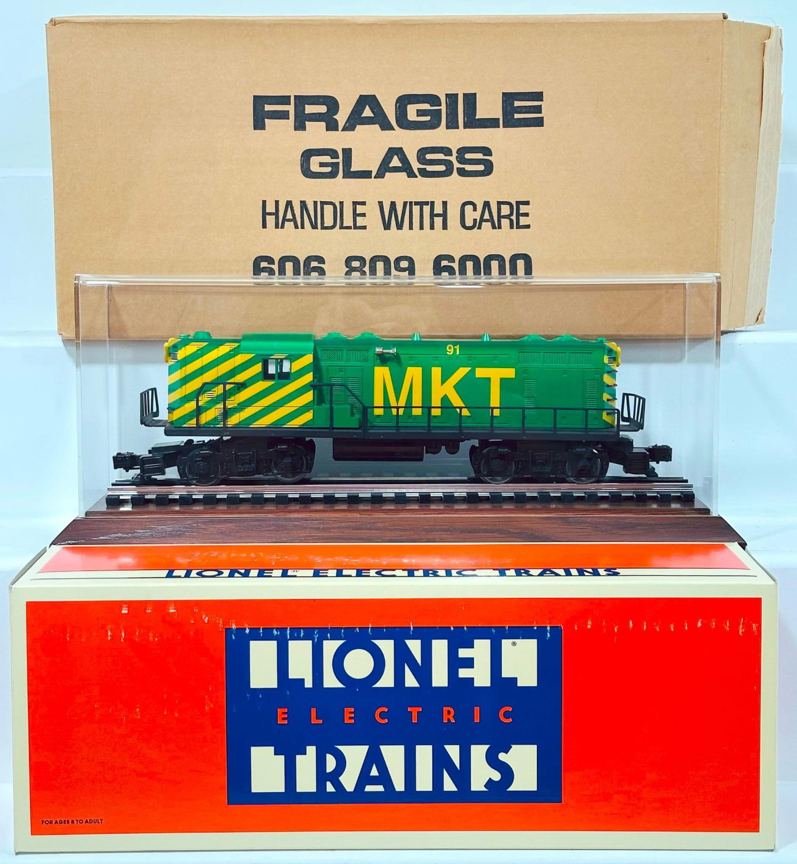 Lionel Modern O Gauge Missouri Kansas & Texas GP - 7 Diesel Switcher Boxed with Plexiglas Showcase: Lionel Modern O Gauge Missouri Kansas & Texas GP - 7 Diesel Switcher Boxed with Plexiglas Showcase, in C9 and with its original box. This Lot includes a Plexiglass Showcase with wood/track base.