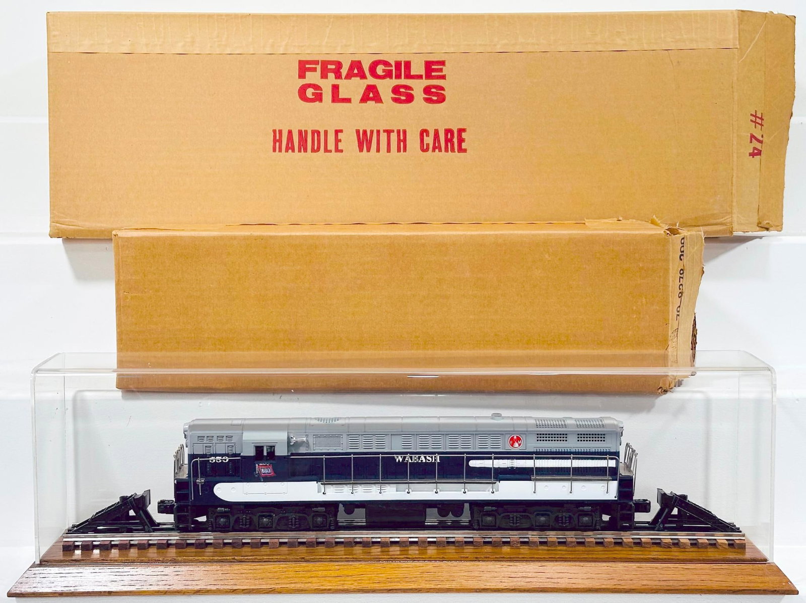 Lionel Modern O Gauge Wabash FM Trainmaster Locomotive Boxed with Plexiglass Showcase: Lionel Modern O Gauge Wabash FM Trainmaster Locomotive Boxed with Plexiglass Showcase, with the Wabash FM Trainmaster in C9 and with its original box and styrofoam packing. This Lot also comes with a 