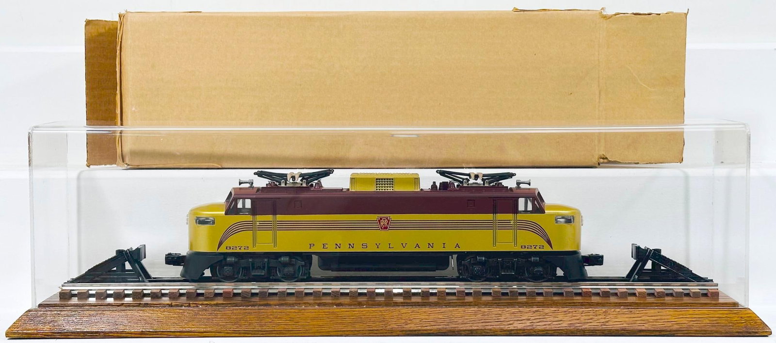 Lionel Modern O Gauge Pennsylvania GP - 5 Electric Locomotive with Plexiglass Showcase: Lionel Modern O Gauge Pennsylvania GP - 5 Electric Locomotive with Plexiglass Showcase, in C9 and with a box. This Lot also comes with a plexiglass showcase with wood/track base.