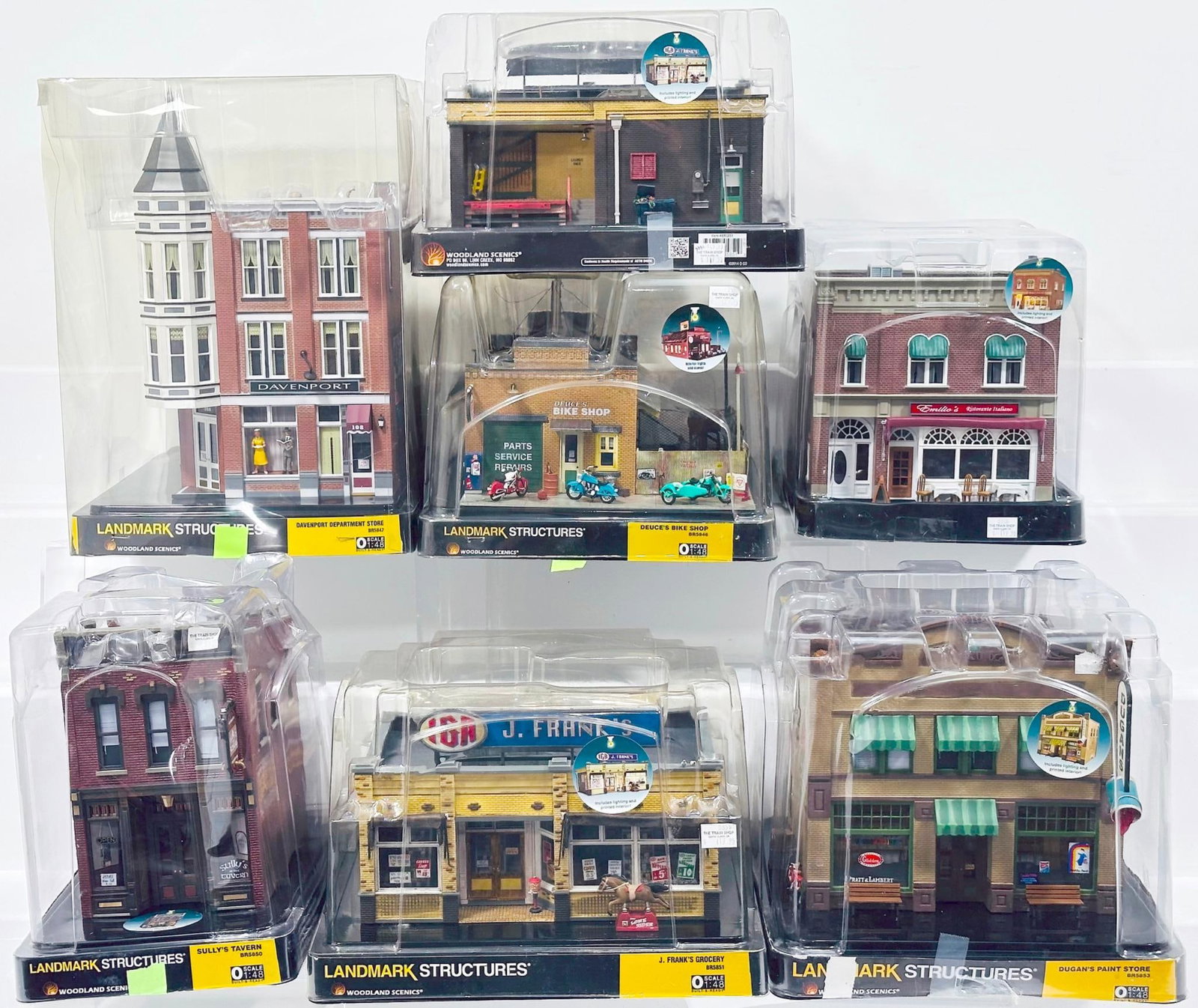 Woodland Scenics Modern O Gauge Seven (7) Assorted Structures with plastic packaging: Woodland Scenics Modern O Gauge Seven (7) Assorted Structures with plastic packaging, including J. Franks Grocery X2, Sully's Tavern, Deuce’s Bike Shop, Davenport Department Store and Dugan’s Feed
