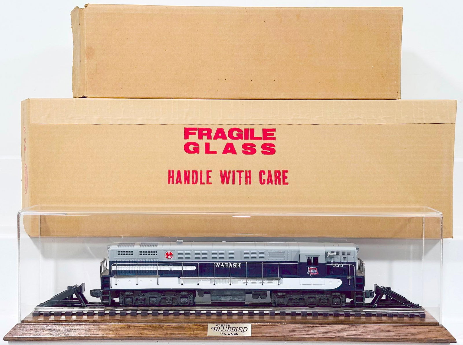 Lionel O Gauge Wabash FM Trainmaster with Showcase Boxed: Lionel O Gauge Wabash FM Trainmaster with Showcase Boxed, in C9 and with its original box, and this Lot also comes a the plexiglass showcase and wood base in its original box.