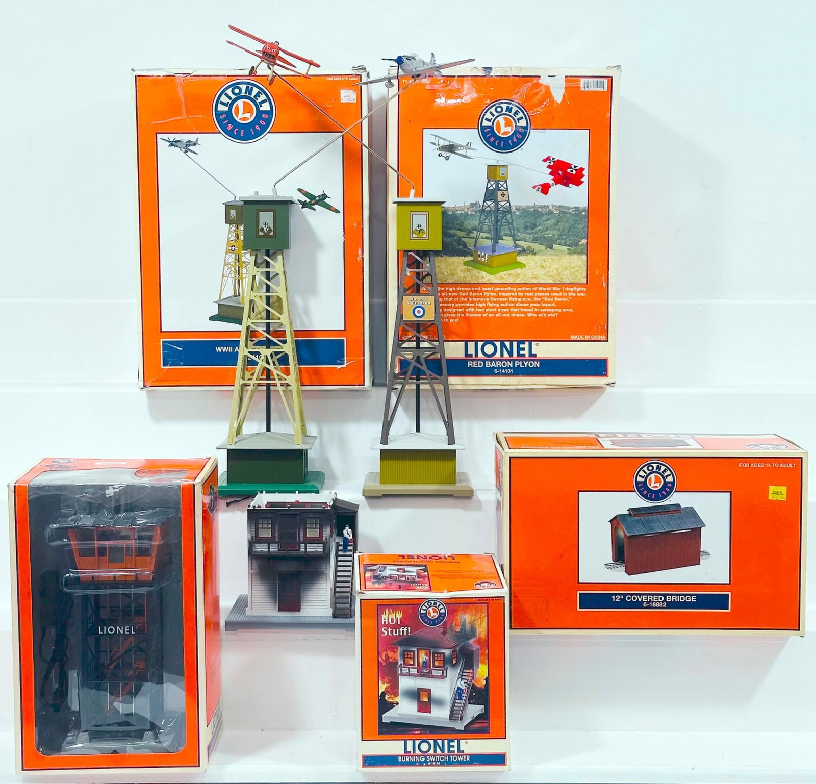 Lionel Modern O Gauge Five (5) Assorted Structures: Lionel Modern O Gauge Five (5) Assorted Structures, including Plug N Play Control Tower, 12 inch Covered Bridge, WWII Airplane Pylon, Red Baron Plyon and Burning Switch Tower, each in C7 plus to C8 mi