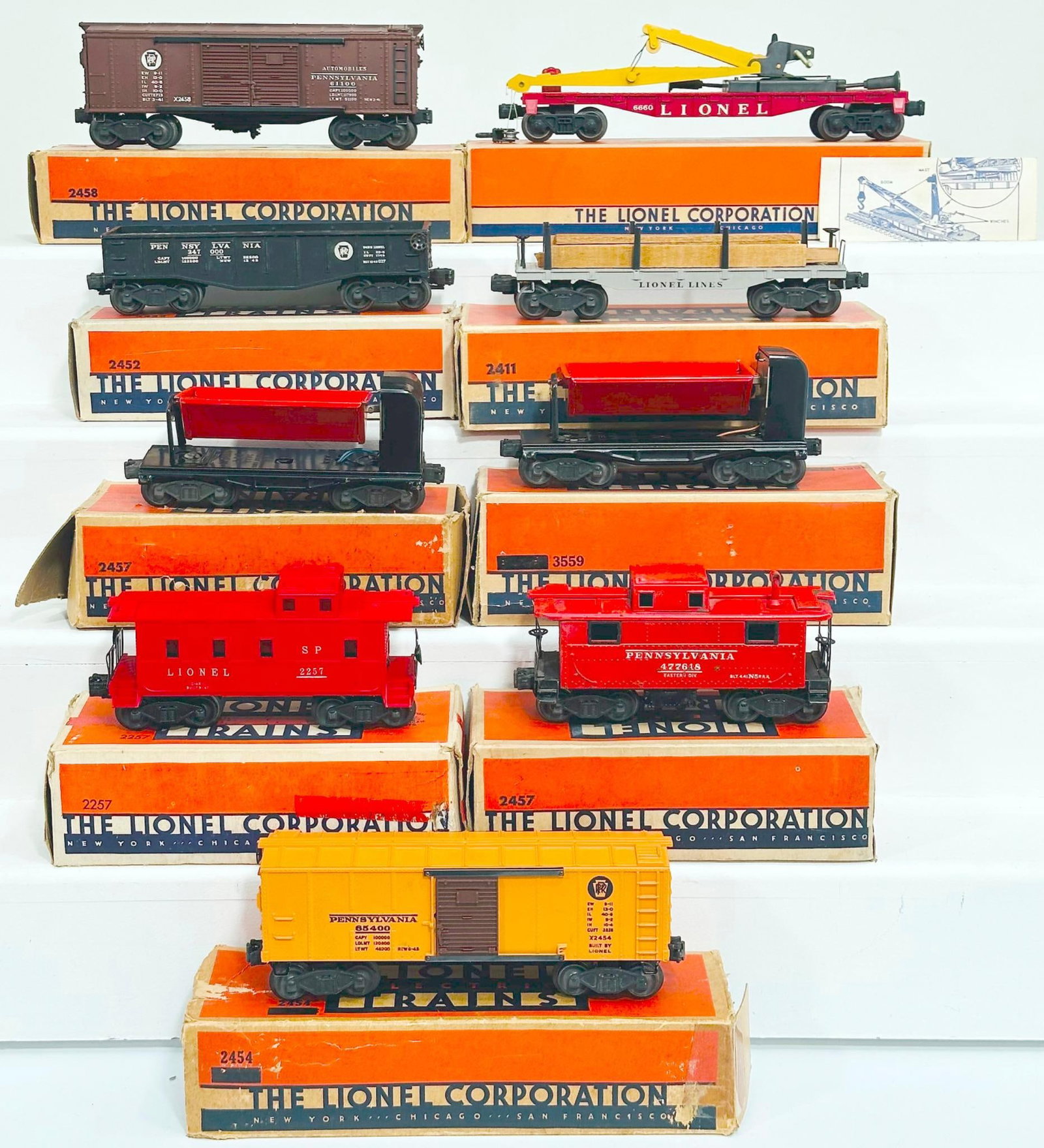 Lionel Postwar O Gauge Eight (8) Assorted Freight Cars: Lionel Postwar O Gauge Eight (8) Assorted Freight Cars, including 2457 Caboose, 2458 Automobile Car, 2454 Box Car, 6660 Boom Crane Car, 2452 Gondola, 3559 Dump Car, 2411 Flat Car, 2457 Caboose and