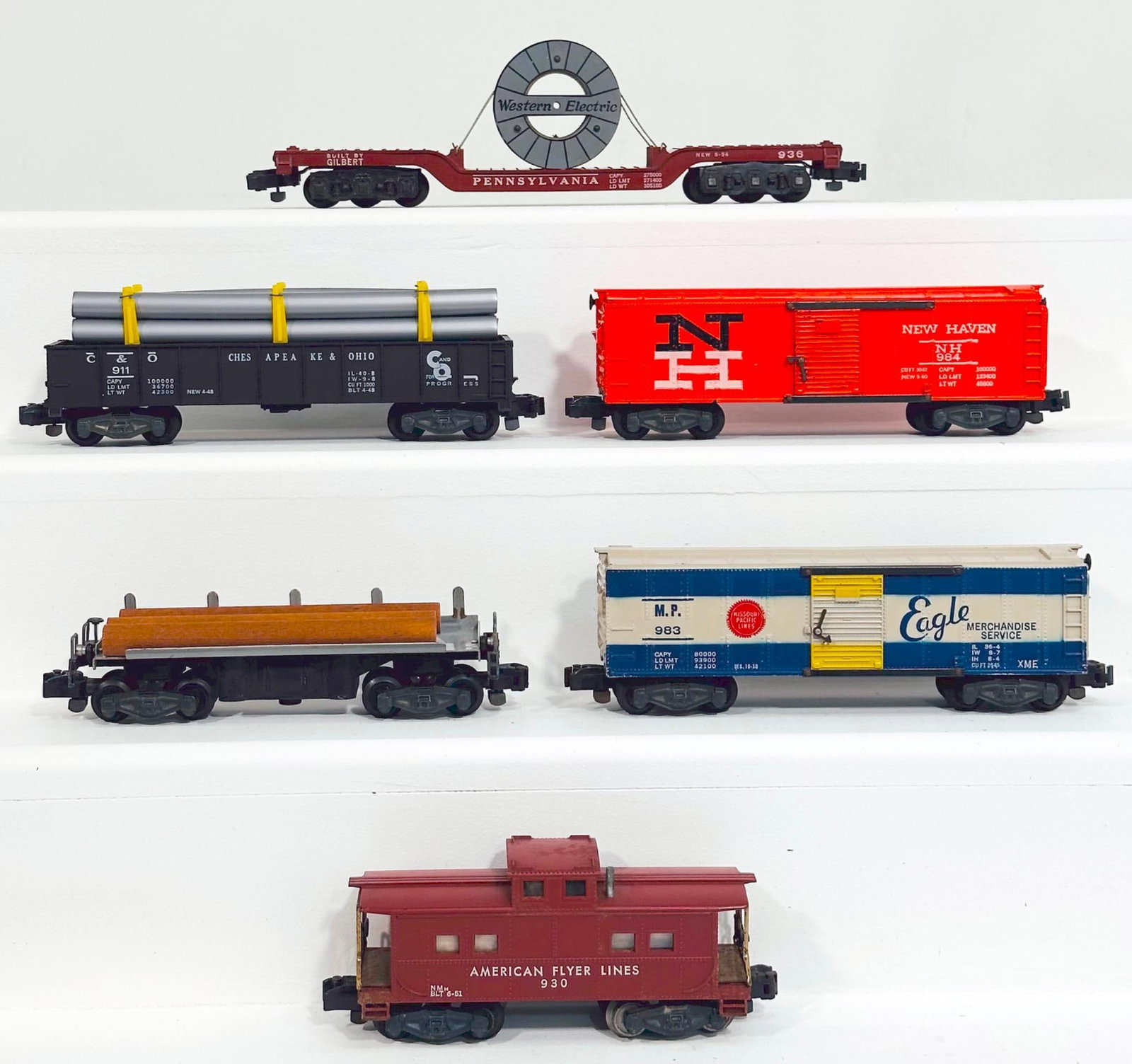 American Flyer Postwar S Gauge Six (6) Assorted Freight Cars: American Flyer Postwar S Gauge Six (6) Assorted Freight Cars, including 984 in C7 plus, 914 log load in C7, 930 in C7, 911 with silver pipe load in C7 plus, 983 in C7 plus and 936 in C7 plus.