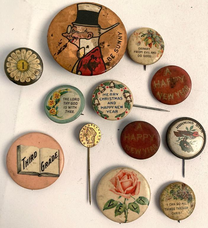 A Group of 11 Floral Advertisement Pins: A grouping of various size floral buttons with slogans and advertisement material, labels include Whitehead and Hoag Co. , David C. Cook Publishing Co. and The American Sunday School Union. Overall go