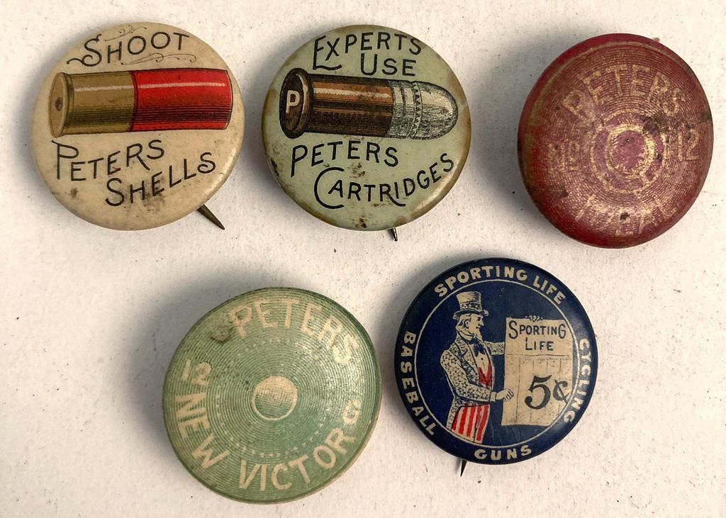 A Group of 5 Firearms Advertisement Pins: A group of 5 firearms related and ammunition advertisement pins, lot includes, Shoot Peters Shells, Expert Use Peters Cartridges, Sporting Life Cycling Baseball and Guns with Whitehead and Hoag verso 