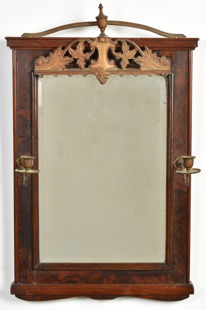 A George III Mahogany Looking Glass: English, 19th century. A beveled looking glass housed in mahogany frame with applied brass candleholders; ht. 26, wd. 17.5, dp 2 inches. Overall good condition. Wear with use and age. Oxidation to met