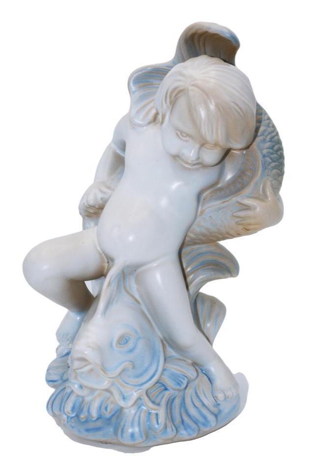 A Rookwood Pottery Gary David Simon "Child with Dolphin" Figurine: American (Cincinnati, Ohio), 21st century. A 2009 Rookwood figurine of a cherub riding a dolphin. Marked MMIX/10041 and measures 5.0" W x 5.0" D x 11" H. Signed "GDS" by artist Ga