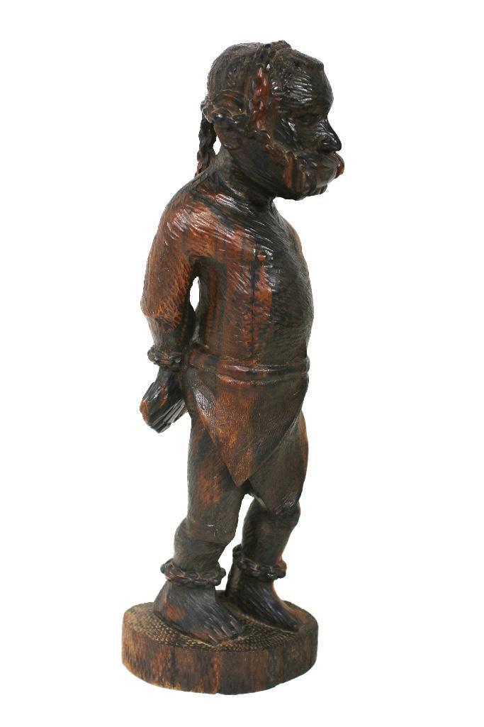 An Abolitionist Carved Sculpture of a Chained Man: American, late 19th century. This is an ebony carved statuette of an enslaved man in chains. The figure is based off a nutcracker from the 1860s used by abolitionists to help solidify anti-slavery sen