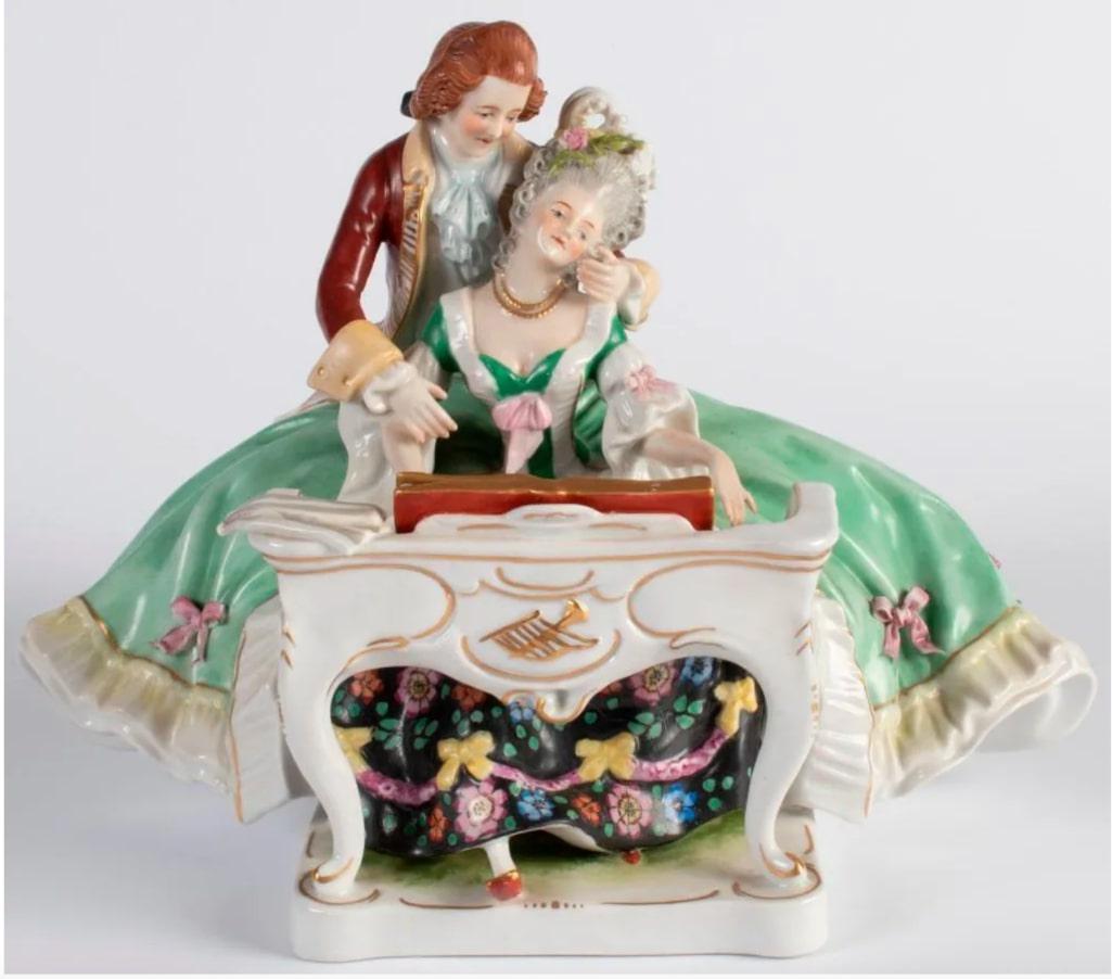A Scheibe-Alsbach FIgural Porcelain of Lady and Man Courting: German, 20th century. A painted figural porcelain of a lady at piano and gentleman courting, marked on base; ht. 7, wd. 9, dp. 6 inches. Provenance: Property from the estate collection of John D. Scho