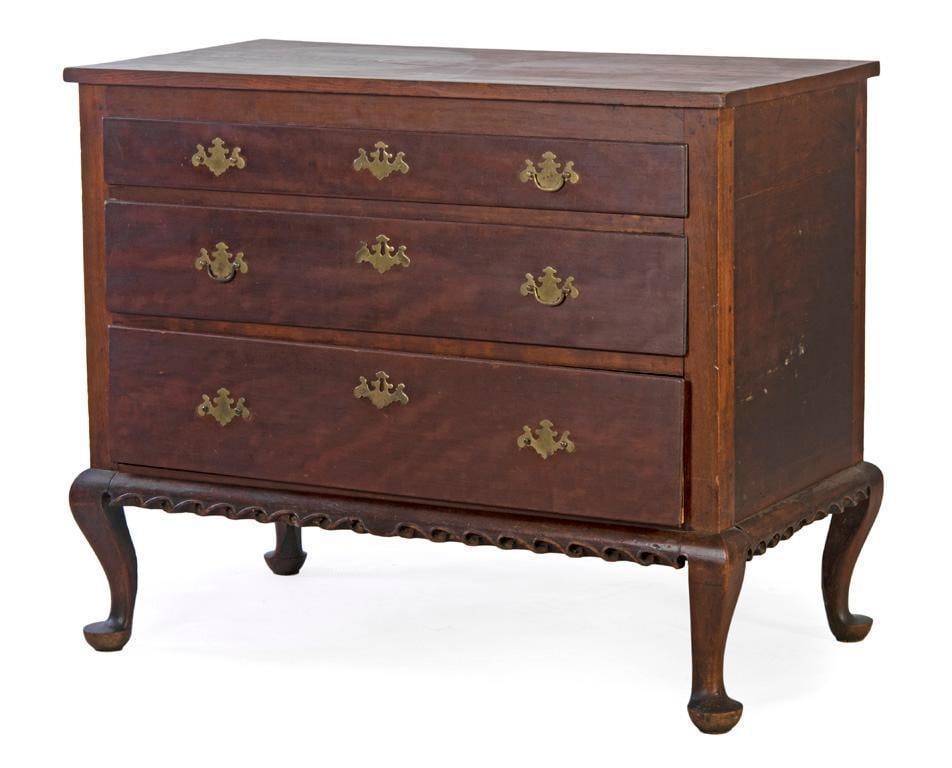 A Late Federal Chest of Drawers in Cherry: American, 19th century. A late federal chest of drawers in cherry , having a rectangular surface, over three graduated and dovetailed drawers with brass pulls, carved and shaped skirt, all rising on q